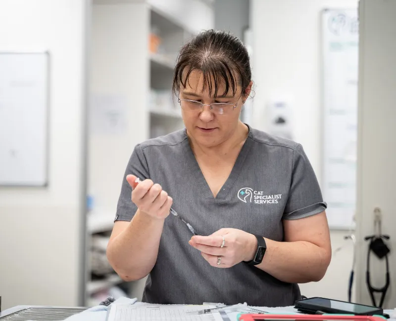 Veterinary nurse holding two syringes