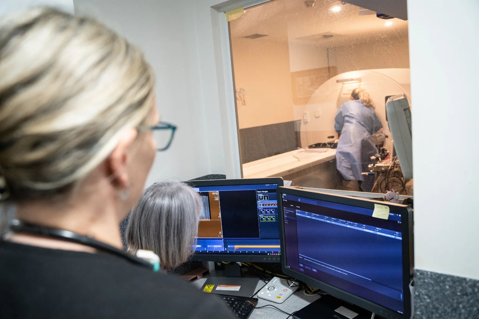 Veterinary staff monitoring a CT scan from the control room.
